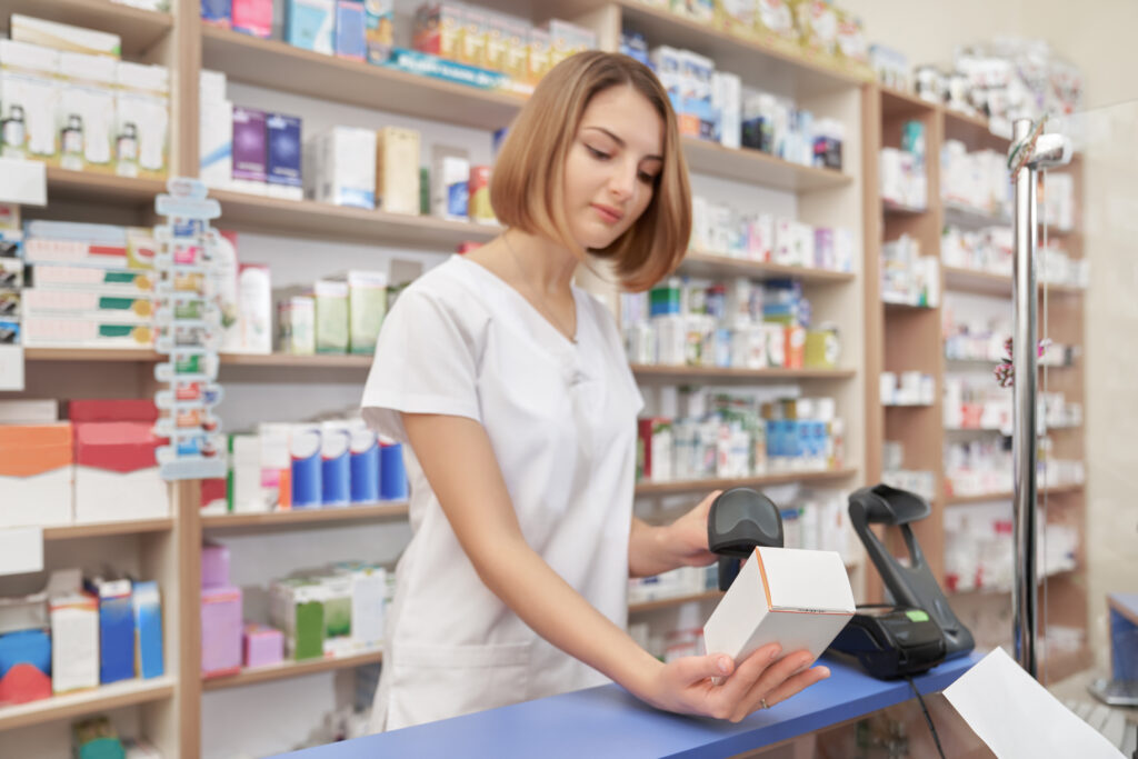 Pharmacist scanning barcode of medical box.